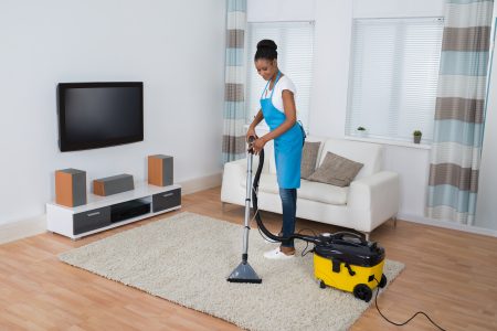 女人用职业吸尘器打扫起居室